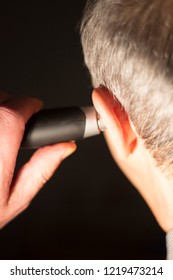 Senior Citizen Man Cutting Inner Ear Hair With Electric Cutter.