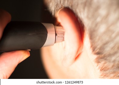 Senior Citizen Man Cutting Inner Ear Hair With Electric Cutter.