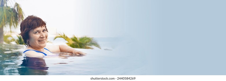 Senior citizen woman relaxes in the infinity pool. Portrait of a retired woman on vacation in swimsuit. woman smiles and looks at the camera. Banner with free space for text - Powered by Shutterstock