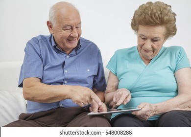 Senior Citizen Working And Playing A Mobile Tablet Computer And Using The Internet