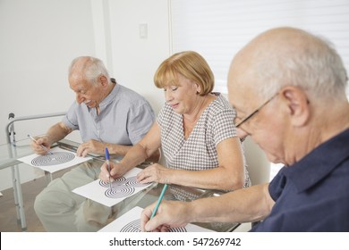 Senior citizens working on cognitive mind puzzles - rehabilitation theme. - Shutterstock ID 547269742