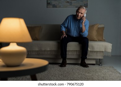 Senior Confident Man Making A Phone Call In Empty Room