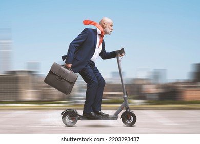 Senior corporate businessman riding an electric scooter in the city