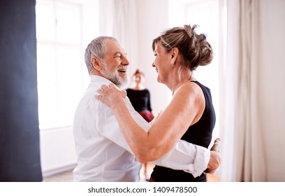 Senior Couple Attending Dancing Class In Community Center.