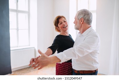 Senior Couple Attending Dancing Class In Community Center.