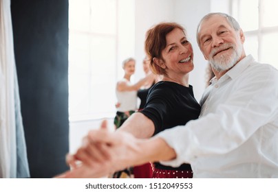 Senior Couple Attending Dancing Class In Community Center.