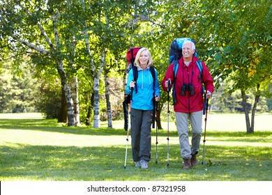 Senior Couple With Backpacks And Trekking Poles. Adventure.