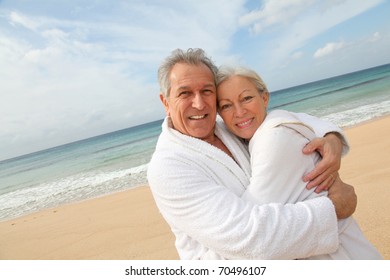 Senior couple in bathrobe at the beach - Shutterstock ID 70496107
