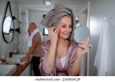 Senior Couple In Bathroom, Brushing Teeth And Looking At Mirror, Morning Routine Concept.