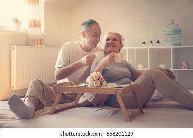 Senior couple in bed. Senior people drinking coffee in bed. - Powered by Shutterstock