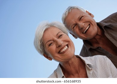 Senior Couple Bending Over Camera