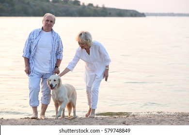 Senior couple and big dog walking on riverside - Powered by Shutterstock