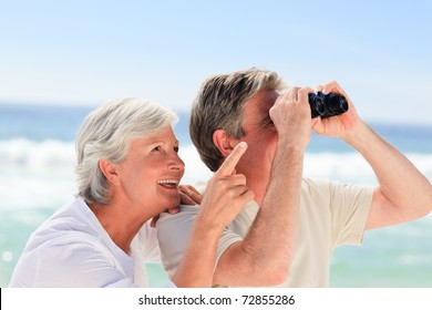 Senior Couple Bird Watching At The Beach