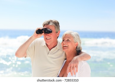 Senior Couple Bird Watching At The Beach