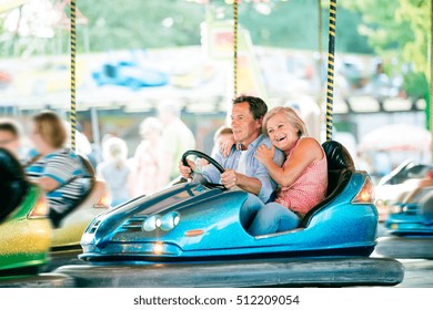 Senior Couple In The Bumper Car At The Fun Fair