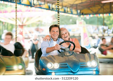 Senior Couple In The Bumper Car At The Fun Fair