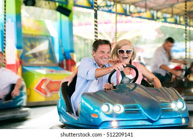 Senior couple in the bumper car at the fun fair - Powered by Shutterstock