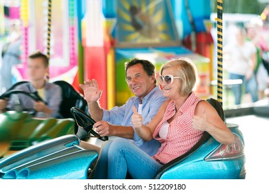 Senior Couple In The Bumper Car At The Fun Fair