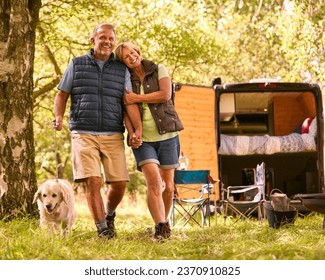 Senior Couple Camping In Countryside With RV Taking Labrador Dog For A Walk - Powered by Shutterstock