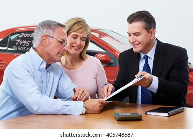 Senior couple with car dealer agent.
