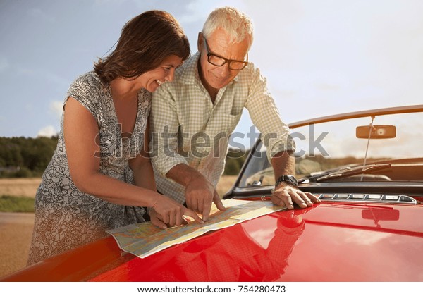 senior couple with car and\
map