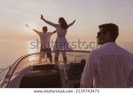 A senior couple in casual outfits with their son enjoy while riding a boat at sea at sunset. The concept of a happy family. Selective focus 