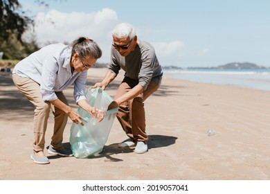 Senior couple collecting rubbish at the beach. environmental protection concept and Good role model - Powered by Shutterstock