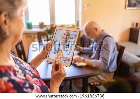 Senior couple consulting with a doctor on digital tablet
