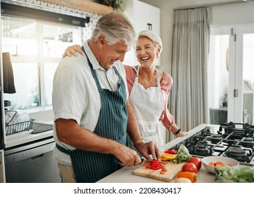 Senior couple, cooking and having fun while preparing a healthy food with vegetables for a vegan meal in the kitchen at home while laughing and having fun. Funny old man and woman helping with dinner - Powered by Shutterstock