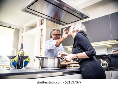 Senior Couple Cooking And Having Fun In The Kitchen