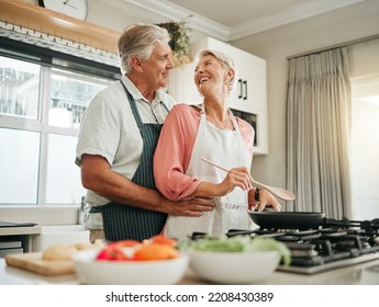 Senior couple, cooking and home bonding for fun, romance and happiness with husband hugging happy wife with love, care and offering help in the kitchen. Food, marriage and joy with old man and woman - Powered by Shutterstock