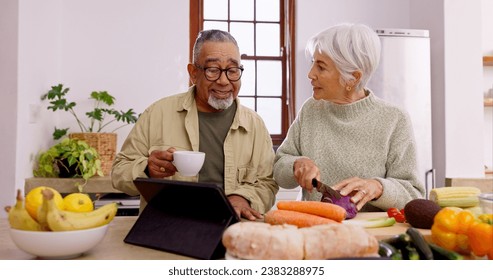 Senior couple, cooking and tablet in home kitchen with knife, vegetables and tea cup for conversation. Interracial marriage, elderly woman and old man with touchscreen for video, food and nutrition - Powered by Shutterstock