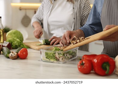 Senior couple cooking together in kitchen, closeup - Powered by Shutterstock