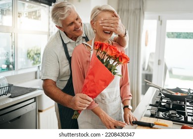 Senior Couple, Covering Eyes And Flowers Surprise As Man Give Wife Bouquet Of Roses On An Anniversary, Birthday Or Valentines Day In Kitchen. Happy Old Man And Woman Being Romantic In Australia House