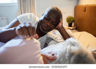 Senior couple cuddling peacefully in bed - Powered by Shutterstock