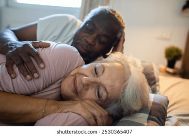 Senior couple cuddling peacefully in bed - Powered by Shutterstock