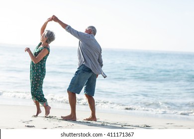 Senior couple dancing at the beach on a sunny day