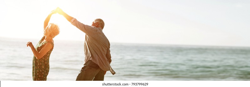 Senior couple dancing at beach on sunny day - Powered by Shutterstock