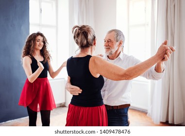 Senior Couple In Dancing Class With Dance Teacher.