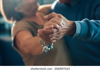 senior couple dancing hand in hand - elderly taking tango course