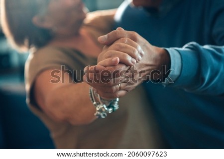 senior couple dancing hand in hand - elderly taking tango course