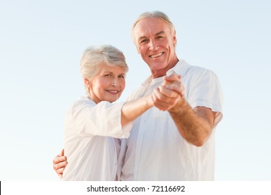 Senior Couple Dancing On The Beach