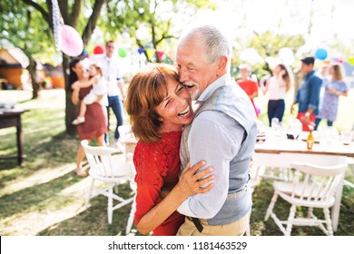 A senior couple dancing on a garden party outside in the backyard. - Powered by Shutterstock