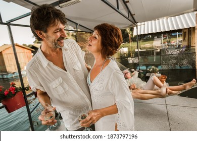 Senior Couple Dancing On A Party Outside Drinking Wine.