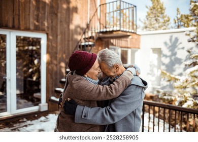 Senior couple dancing outside winter cabin - Powered by Shutterstock