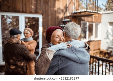 Senior couple dancing outside winter cabin - Powered by Shutterstock