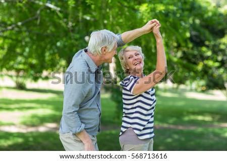 Senior couple dancing in park