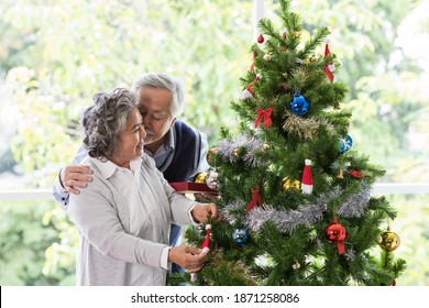 Senior couple decorating Christmas tree together at home. Elderly couple spending time, relaxing on Christmas day. Merry Christmas and Happy Holidays. Christmas holiday celebration - Powered by Shutterstock