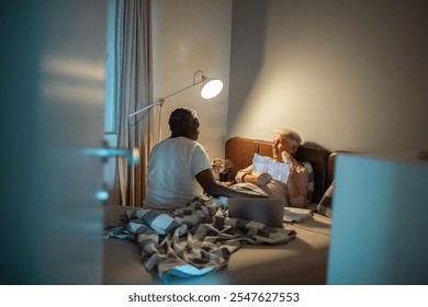 Senior couple discussing medical bills in bed at night - Powered by Shutterstock