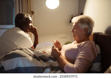 Senior couple discussing medical bills in bed at night - Powered by Shutterstock